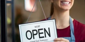 Salon Showdown Over ‘Israeli’ Stuns Virginia Shop worker holding an open sign