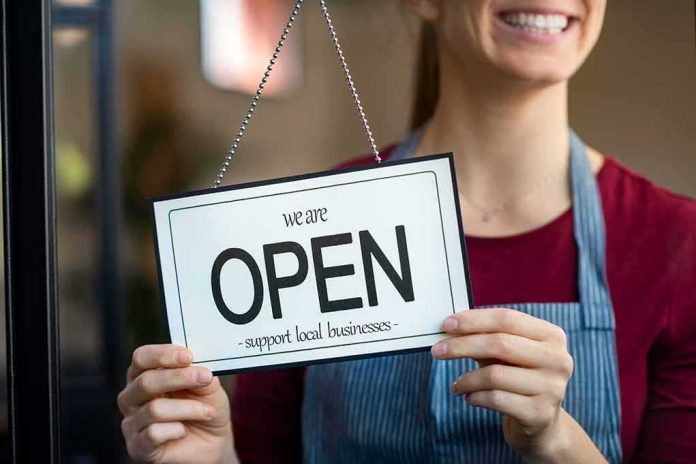 Shop worker holding an open sign