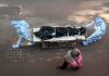 health workers in PPE move a body on a stretcher