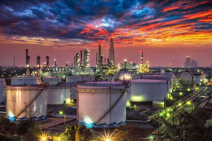 Oil refinery with storage tanks at sunset