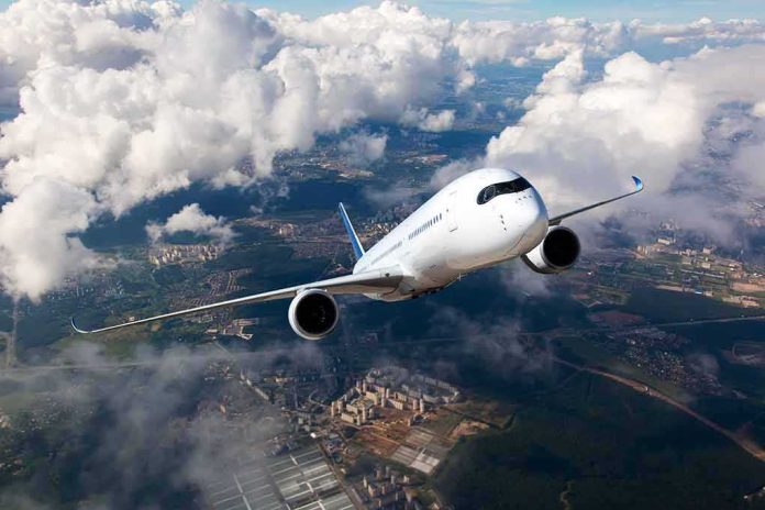 shutterstock_523950889 Commercial jet airliner flying above clouds