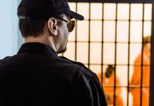 Policy Uproar: Age 50 Parole Fight Security guard watching inmates behind jail bars