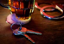 House keys on bar beside beer mug and handcuffs