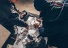 Triple-Digit Shock – The Iran Stat They Hide Two people sorting stacks of U.S. dollar bills on a table
