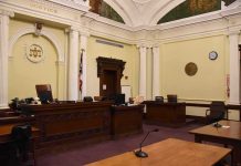 CIA Gold Hoard Triggers Shocking Plea Twist empty courtroom with judge's bench and columns