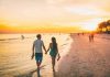 couple walking on a beach at sunset