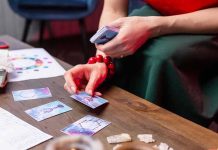 Person laying tarot cards on a wooden table