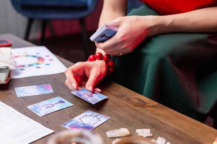 shutterstock_1342002137 Person laying tarot cards on a wooden table