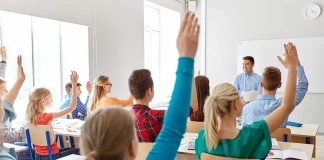 Students raising hands in a classroom