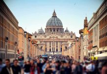 St. Peter's Basilica viewed from a busy street with crowds