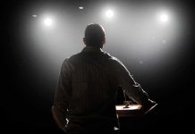 Speaker on stage under bright spotlights