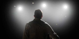 A Longtime Las Vegas Star Is Hospitalized Speaker on stage under bright spotlights