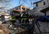 Firefighters assess damage at a collapsed residential building