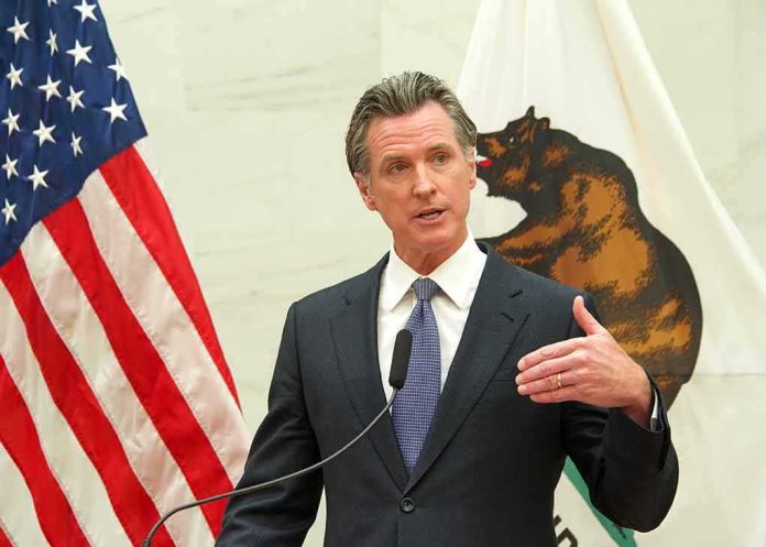 shutterstock_2150863011 Gavin Newsom speaks at a podium with U.S. and California flags behind him