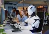 Factory Fever: Humanoids Go Mass-Market Robot and office workers at computers in a modern workspace