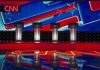 Fox Host’s Low Blow Sparks Firestorm Debate stage with four podiums and colorful star backdrop