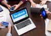 Laptop with Facebook on screen surrounded by smartphones