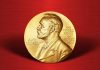 Gold Nobel Prize medal on red background.