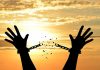 Silhouette hands breaking chains at sunset