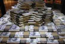 Stacks of U.S. hundred-dollar bills arranged in a pyramid