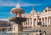 Stone fountain in front of a grand basilica with dome and colonnade