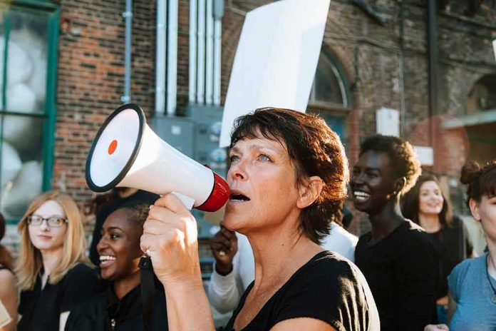 shutterstock_1250469094 Woman with megaphone leading a protest