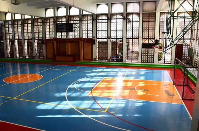 shutterstock_1350851069 Indoor basketball court with blue floor and orange key areas