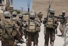 Exit Complete, Deterrence Gets Tested soldiers in desert fatigues with radio packs and antennas