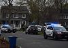 Police SUVs with lights on block a suburban street