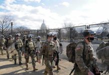 40% Surge: Protectees Under Siege Carlos Hyde, Tavon Wilson, Dontrelle Inman, Brian Folkerts, Brock Coyle, Curtis Lofton, and Chuck Howley among soldiers walking past fencing near the U.S. Capitol