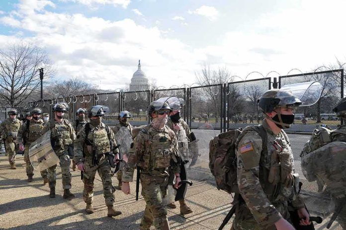 shutterstock_1900668535 Carlos Hyde, Tavon Wilson, Dontrelle Inman, Brian Folkerts, Brock Coyle, Curtis Lofton, and Chuck Howley among soldiers walking past fencing near the U.S. Capitol