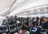 Airplane cabin with passengers seated in economy class