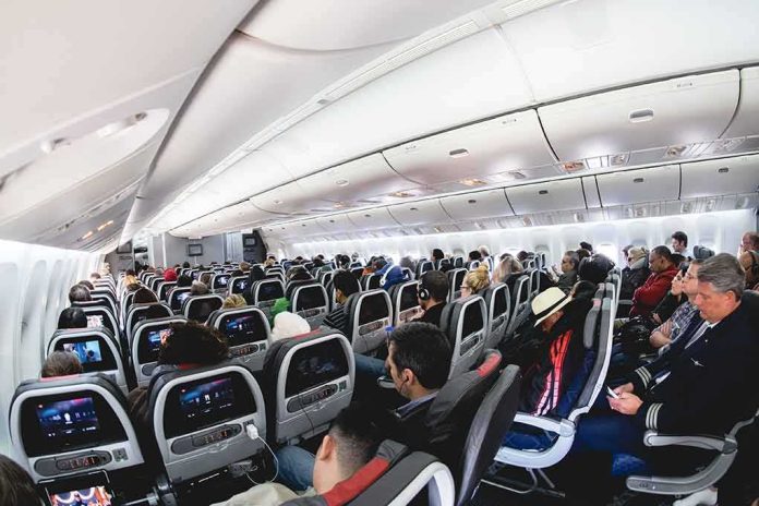 shutterstock_2013481865 Airplane cabin with passengers seated in economy class