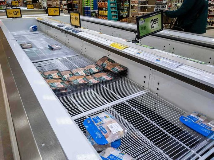 shutterstock_2100205459 supermarket freezer with mostly empty shelves and a few meat packages