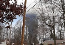 Cameras Captured What Happened Next Suburban street with large plume of dark smoke rising beyond trees