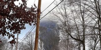 Cameras Captured What Happened Next Suburban street with large plume of dark smoke rising beyond trees