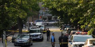 Chainsaw Horror Stuns Alabama Court Police officers secure a residential street with patrol cars and yellow tape