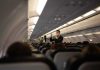 Flight attendant demonstrates safety procedures in airplane cabin