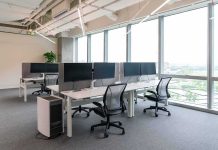 Modern open-plan office with workstations by large windows