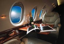 private jet cabin with leather seat, champagne and magazine on table