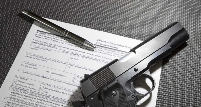 shutterstock_581003293 Handgun on firearm transaction form with pen