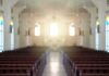 Empty church interior with sunlight at the altar
