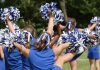 cheerleaders performing with blue and white pom-poms