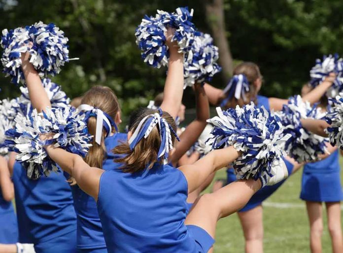 cheerleaders performing with blue and white pom-poms