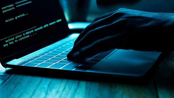 1166453734 Hand typing on laptop with code on screen.