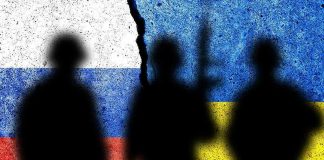 Silhouettes against split Russian and Ukrainian flags