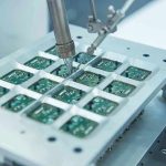 Robotic arm assembling electronic circuit boards in production