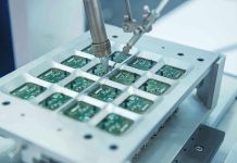 Robotic arm assembling electronic circuit boards in production