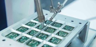 Robotic arm assembling electronic circuit boards in production