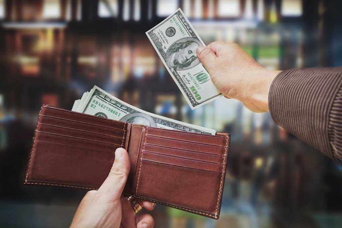 shutterstock_138153356.jpg A hand withdrawing cash from a wallet in a blurred background